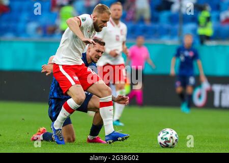 14. Juni 2021, Russland, St. Petersburg: Fußball: Europameisterschaft, Polen - Slowakei, Vorrunde, Gruppe E, Spieltag 1 im St. Petersburger Stadion. Der polnische Tymoteusz Puchacz (vorne) und der slowakische Lukas Haraslin kämpfen um den Ball.wichtig: Nur für redaktionelle Berichterstattung. Ohne vorherige schriftliche Genehmigung der UEFA nicht für kommerzielle oder Marketingzwecke verwendet. Bilder müssen als Standbilder erscheinen und dürfen keine Matchaction-Videoaufnahmen emulieren. Fotos, die in Online-Publikationen veröffentlicht werden (ob über das Internet oder anderweitig), müssen ein Intervall von mindestens 20 Sekunden haben Stockfoto