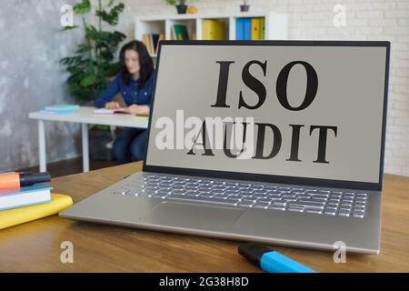 Laptop mit ISO-Audit-Bericht auf dem Schreibtisch. Stockfoto