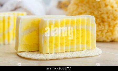 Natürliche handgemachte Seifenstücke. Duftende Seifenstücke für Spa-Behandlungen mit Loofah-Schwamm, natürlichem Seegrubber. Toilettenartikel und Bad kosmetisches Produkt für Stockfoto