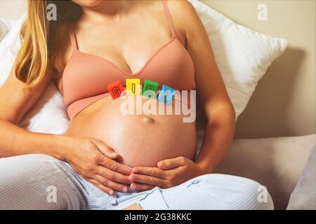 Schwanger Frau halten Bauch mit Mädchen Wort auf sie Stockfoto