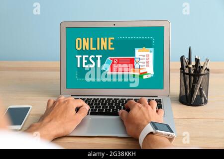 Mann mit Laptop, der zu Hause online die Prüfungen abgibt Stockfoto