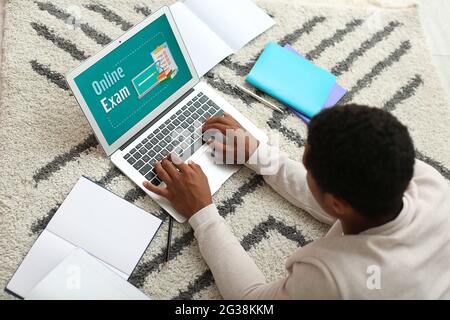 Afroamerikanisch mit Laptop, der die Prüfungen online zu Hause abgibt Stockfoto
