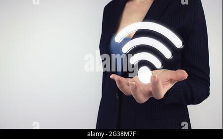 Business Networking Verbindungskonzept und Wi-Fi Konzept. Hand halten digitales Hologramm WIFI-Symbol auf grauem Hintergrund Stockfoto