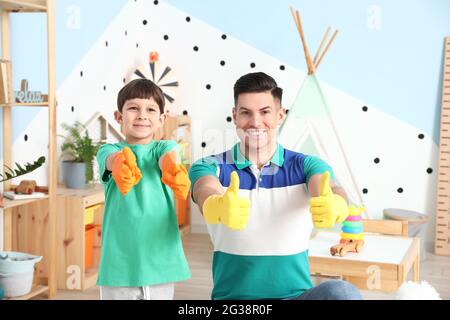 Vater und Sohn zeigen zu Hause Daumen nach oben Stockfoto