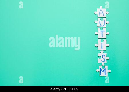 Wort AUTISMUS aus Puzzles auf farbigem Hintergrund Stockfoto