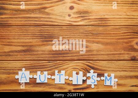 Wort AUTISMUS aus Puzzles auf Holzhintergrund Stockfoto