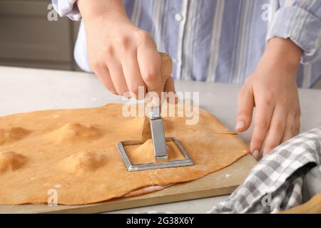 Weibliche Köchin macht leckere Ravioli am Tisch, Nahaufnahme Stockfoto