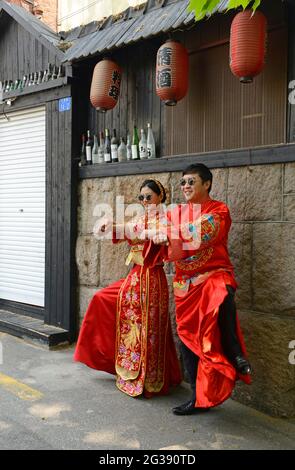 Ein Paar hat vor dem großen Tag seine Hochzeitsfotos in der Altstadt von Qingdao, China, in traditioneller chinesischer Kleidung. Stockfoto