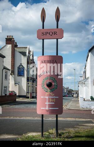 Schild mit Legionärschild und Speeren, der zur archäologischen Stätte der römischen Festung Arbeia in South Shields an der Mündung des Flusses Tyne führt. Stockfoto