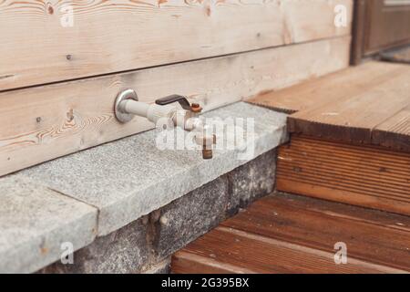 Wasserhahn an der Hauswand Stockfoto