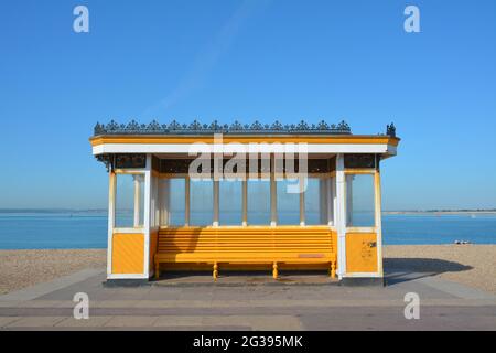 Strahlend gelb und weiß Windschutz an der Südseeküste. Platz zum Sitzen und Blick über den Solent zur Isle of Wight Stockfoto