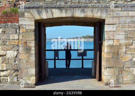 Ein Mann steht auf dem Meer, mit der Hand auf dem Gesicht gibt es ein Gefühl des Denkens oder Nachdenkens. Stockfoto