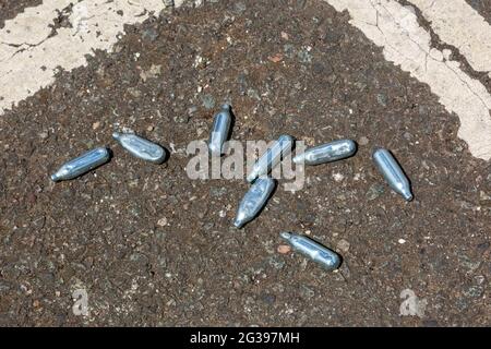 Lachgas-Kanister auf einer Straße, Großbritannien Stockfoto