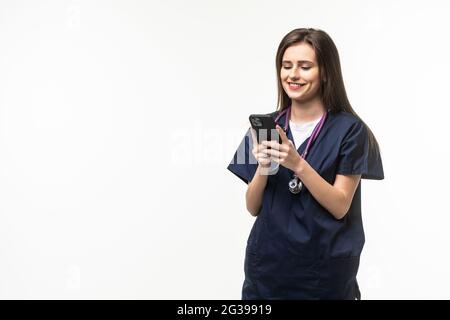 Der Arzt schaut in das Telefon und schreibt sms isoliert auf grauem Hintergrund Stockfoto