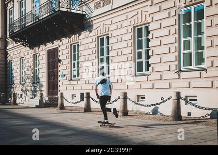 Mann auf einem Skateboard in lässiger Kleidung, Straßen der Stadt Stockfoto