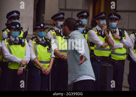 London, Großbritannien. Juni 2021. Ein Protestler verhöhnt die Polizei in Whitehall. Anti-Sperren-, Anti-Impfstoff- und Anti-Maske-Demonstranten versammelten sich vor den Houses of Parliament und Downing Street, als die Regierung ankündigte, dass die Aufhebung weiterer COVID-19-Beschränkungen bis zum 19. Juli verschoben wird. (Kredit: Vuk Valcic / Alamy Live News). Stockfoto