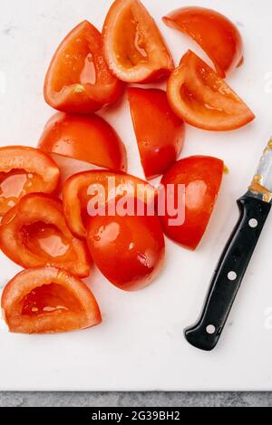 Frische, von Weinreben gereifte Tomaten auf einem Schneidebrett Stockfoto