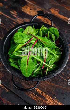 Frisches, rohes, gemischtes Gemüse, Spinat, mangold und Rucola. Dunkler Holzhintergrund. Draufsicht Stockfoto