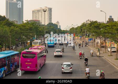 Eine verkehrsreiche, nicht markierte Straße mit Autos, Bussen und Motorrädern in Hanoi, Vietnam Stockfoto