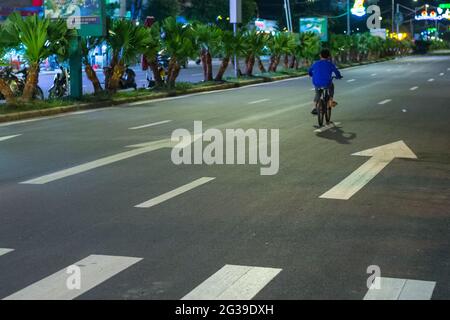 Ein Radfahrer auf einer ruhigen mehrspurigen Straße in Cat Ba, Vietnam Stockfoto