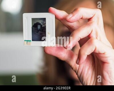 CREMO, ITALIEN - 11. Jun 2021: Ältere elegante kaukasische blonde Frau mit 35-mm-Dia, die sie emotional berührt Stockfoto