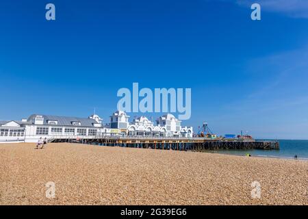 Blick auf den South Parade Pier in Southsea entlang des steinigen Strandes an einem sonnigen Tag, Portsmouth, Hampshire, Südküste Englands Stockfoto