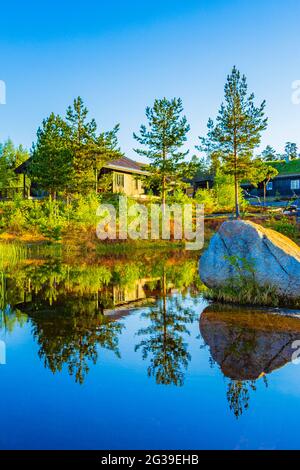 Morgenaufgang mit Spiegelung im Seenfluss in der Naturlandschaft Norwegens in Treungen Urlaubsresort in Nissedal Norwegen. Stockfoto