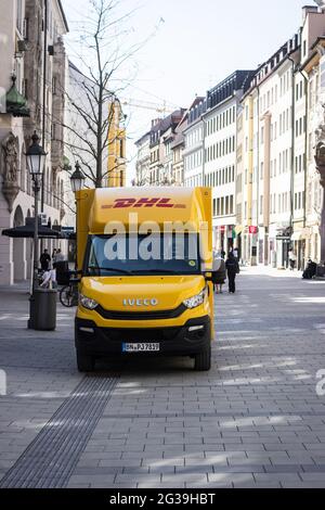 MÜNCHEN, 12. Jun 2021: DHL Transporter parkt in einer Fußgängerzone, gelbes Fahrzeug der Deutschen Post Stockfoto