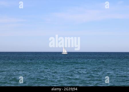 Eineres weißes Segelboot auf offenem Meer Stockfoto