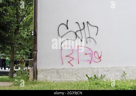 PRAG, TSCHECHISCHE REPUBLIK - 23. Jun 2010: Prag, Tschechische Republik, 23. Juni 2010. Graffitti auf einem Mehrfamilienhaus im Vorort Letnany mit Gras und Bäumen Stockfoto