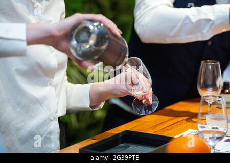 Das Barpersonal goss Gin während einer Gin-Verkostung Stockfoto