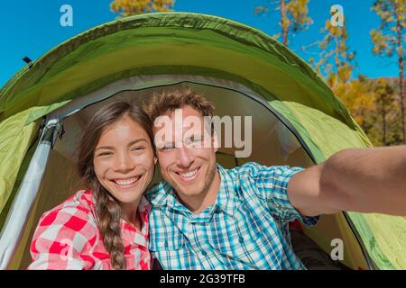 Paar Touristen Camper nehmen Selfie im Zelt Camping auf Sommer Abenteuer Urlaub Reise lächelnd an der Kamera. Gesichter Selbstporträt asiatische Frau und Stockfoto