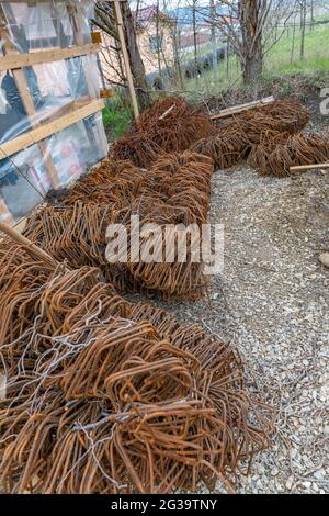 Vertikale Aufnahme von Stahlbaustapeln auf dem Boden im Garten Stockfoto