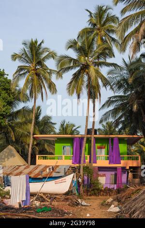 Farbenfrohe Strandhütten unter Palmen und blauem Himmel, Agonda, Goa, Indien Stockfoto