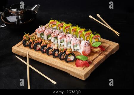 Set aus drei Arten von Sushi-Rollen für zwei Personen auf Holzbrett Stockfoto