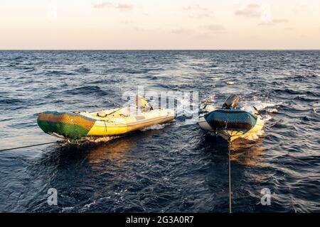 Zwei große, schnell leere Schlauchboote, die von einem Tauchmotorboot geschleppt werden, Rotes Meer, Sudan. Stockfoto