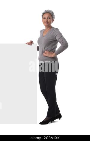 Asiatische Frau mittleren Alters zeigt Whiteboard-Zeichen isoliert auf weißem Hintergrund Stockfoto