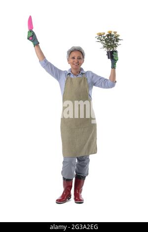 Gartenarbeit. Reife Frau Gärtner Arbeiter mit Blumen in Topf und Schaufel isoliert auf weißem Hintergrund, volle Länge Porträt Stockfoto