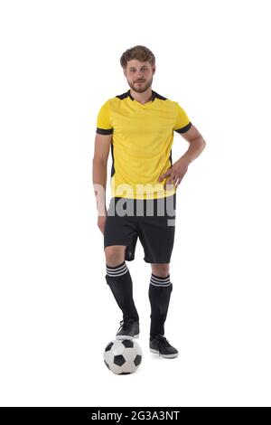Fußballspieler, der mit einem Fuß auf einem Ball auf weißem Hintergrund steht Stockfoto