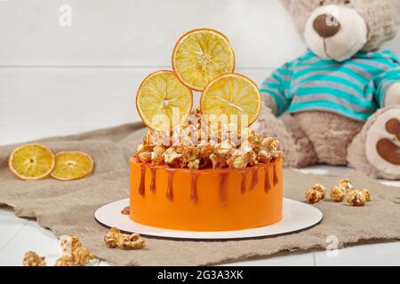 Orangenkuchen mit karamellisiertem Popcorn und kandierten Zitrusscheiben Stockfoto