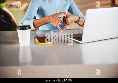 Charmante Online-Lehrer mit Technologie, um mit internationalen Gebärdensprache in hellen Büro zu kommunizieren Stockfoto