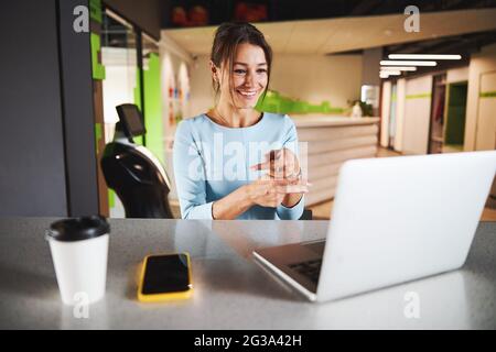 Schöne elegante Geschäftsfrau in formeller Kleidung mit Gespräch auf Videoanruf, während sie gestikulieren Stockfoto