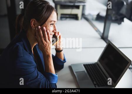 Elegante kaukasische Rechtsanwältin mit modernen Geräten während der Arbeit im Schrank Stockfoto