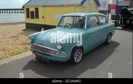 Klassischer blauer Ford Anglia von Strandhütten an der Felixstowe Promenade. Stockfoto