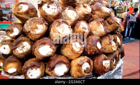 Ein Haufen Blätterteiggebäck, gefüllt mit Schlagsahne in Pulverzuckerbeschichtung, wird auf dem indischen Markt verkauft Stockfoto