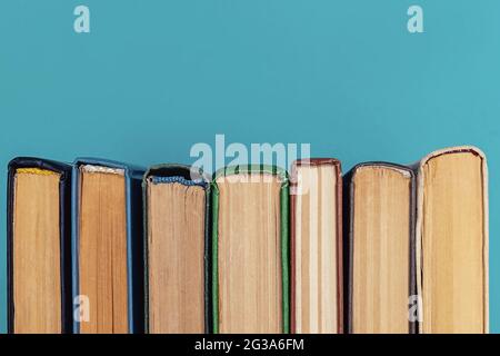 Draufsicht auf bunte Hardback-Bücher in einer Reihe Stockfoto
