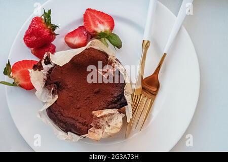 Baskischer Schokoladenkäsekuchen und Erdbeeren Stockfoto