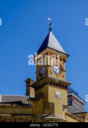 Staycation Idee. Eastbourne Railway Station Uhrenturm, mit Wappen, gegen einen wolkenlosen blauen Himmel. East Sussex, Großbritannien Stockfoto