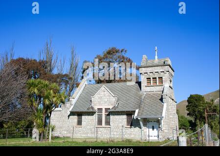 St. Oswald's Memorial Church, Wharanui, Kaikoura Coast, Malborough, Neuseeland. Hübsche kleine Steinkirche in einer grünen ländlichen Landschaft Stockfoto