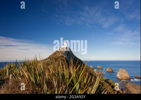 Nugget Point Lighthouse, Catlins Coast, Neuseeland. Atemberaubende Szene, sonnige, Vordergrund, tiefblaue Meer und Himmel Stockfoto